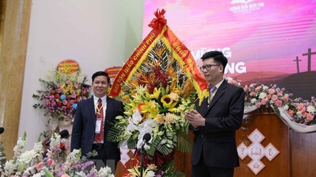 越南政府宗教委员会副主任阮进仲（左）向大会送花。（图片来源：越通社）