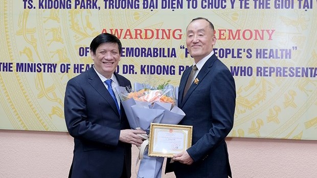 越南卫生部长阮青龙向世界卫生组织驻越南首席代表朴启东博士授予“致力于人民健康”纪念章。