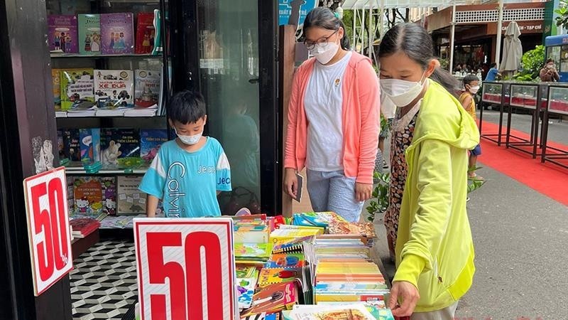 许多家庭带着孩子赴胡志明市书街参观、购物。（图片来源：人民报网）