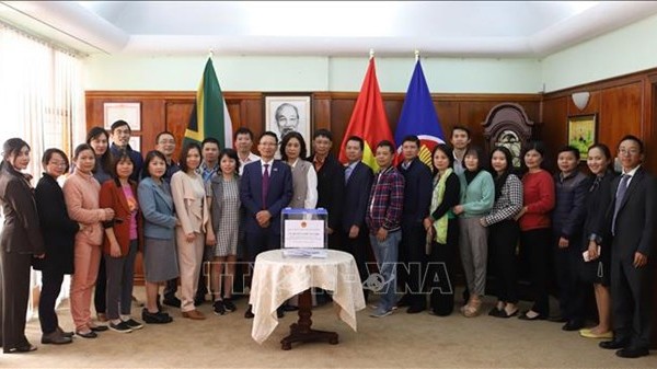 使馆干部和人员、越南驻南非代表机构和越侨代表合影。（图片来源：越通社）