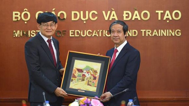 阮金山部长向老挝教育与体育部部长普·西玛莱冯赠送礼品。