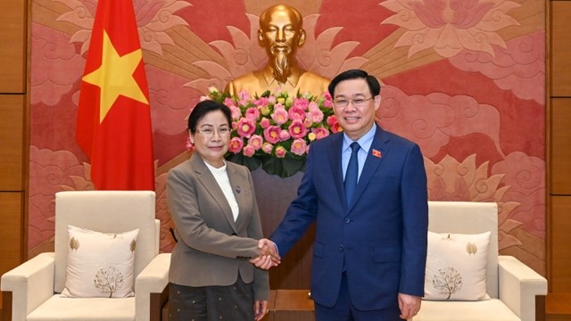 国会主席王廷惠与老挝最高人民法院院长万通•西潘敦握手。