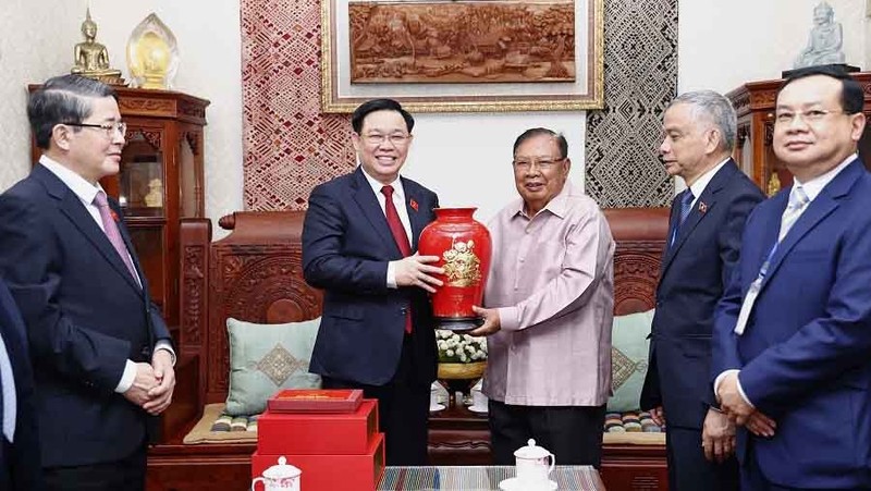 越南国会主席王廷惠向前老挝人民革命党中央总书记、国家主席本扬·沃拉吉赠送纪念品。（图片来源：越通社）