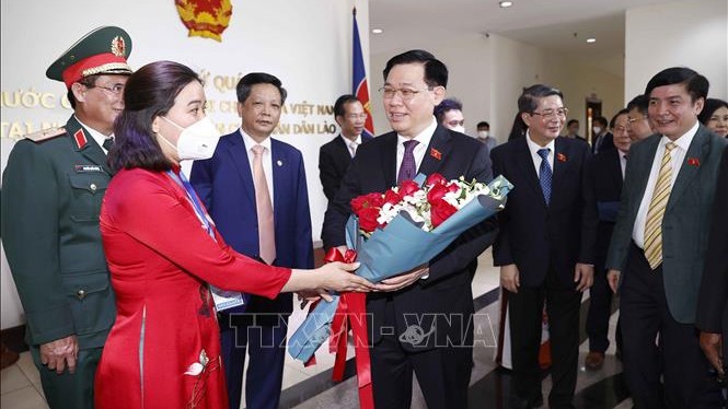 越南驻老挝大使馆官员和工作人员送花欢迎国会主席王廷惠。（图片来源：越通社）