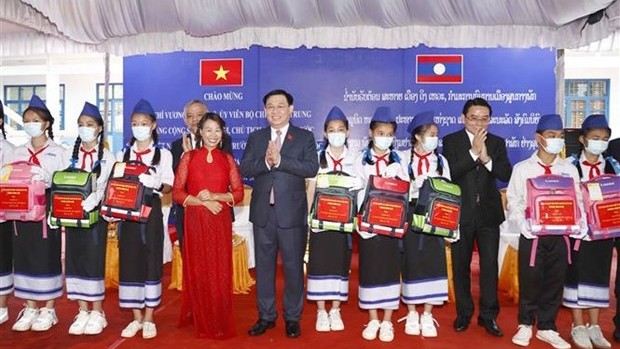 越南国会主席王廷惠向占巴塞寄宿制学校优秀学生送上慰问品。（图片来源：越通社）