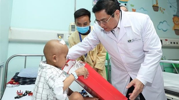 范明正总理向儿童患者赠送慰问品。